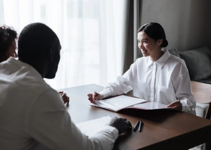 Une femme et un homme assis à une table, examinant un document ensemble